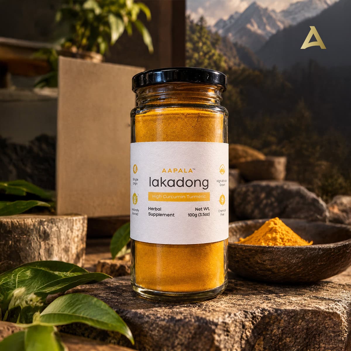 A glass jar of Aapala Lakadong High Curcumin Turmeric herbal supplement, filled with vibrant golden-yellow powder, set on a rustic stone surface with a bowl of loose powder and green leaves in the foreground.